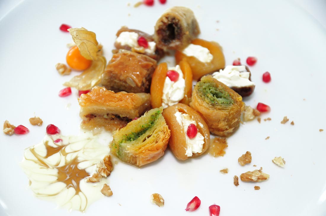 Mit Käsecreme gefüllte getrocknete Aprikosen und Datteln an Baklava Variation mit Granatapfelkernen und Walnusssplittern